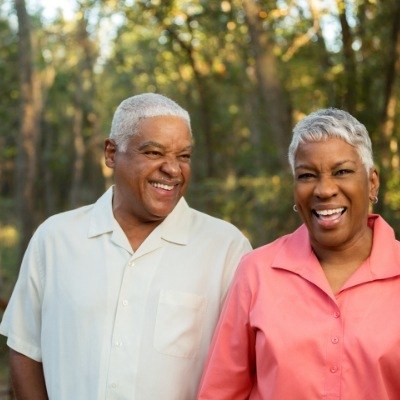 Man and woman enjoying the benefits of combining dentures and dental implants